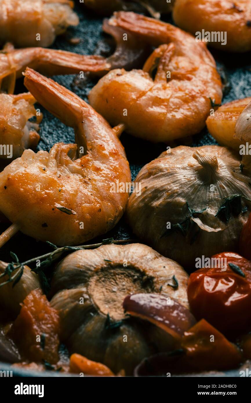 Headless prawns with crispy crust lying with stewed garlic Stock Photo