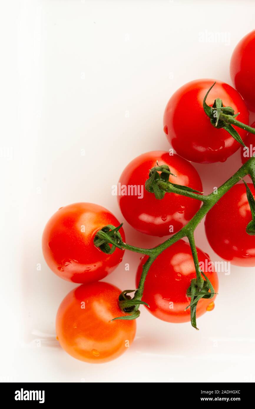 Vertical image with cherry tomatoes on white surface Stock Photo - Alamy