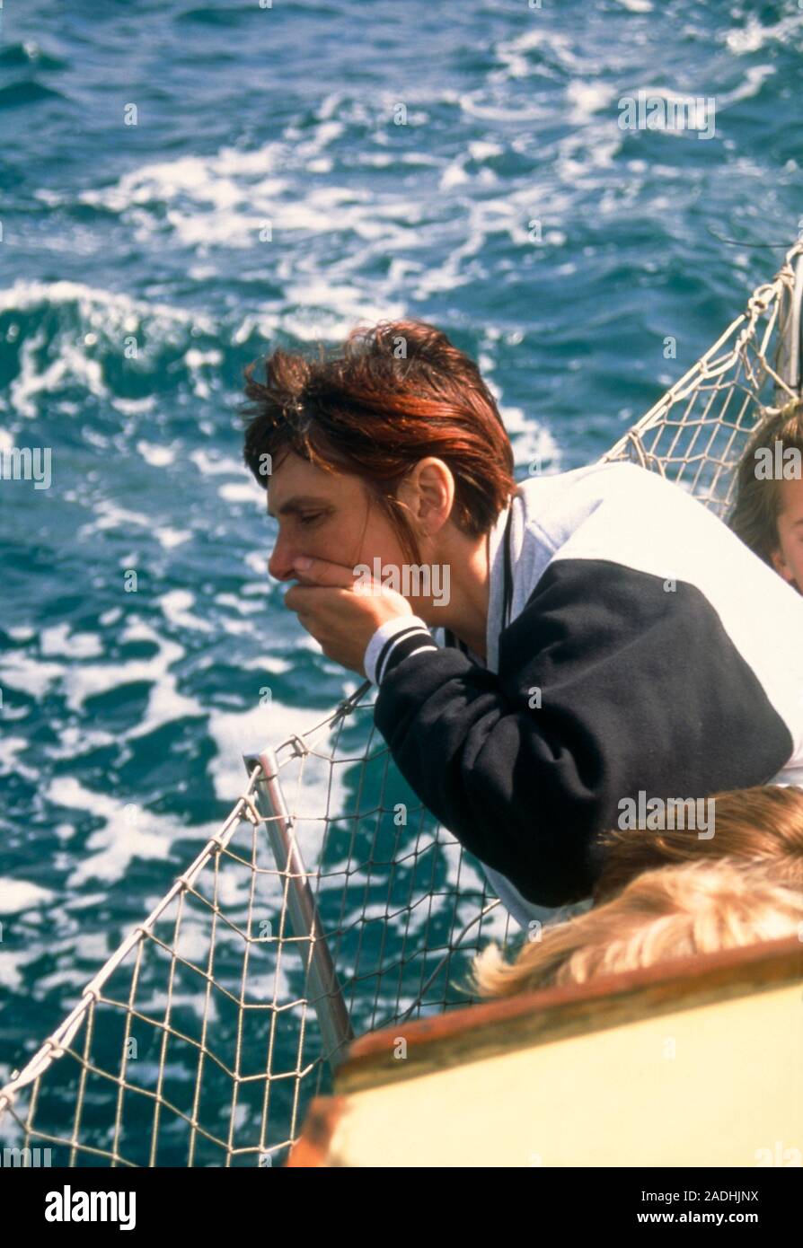 Seasickness. View of a woman holding her hand to her mouth on a boat, suffering from seasickness. Seasickness is a form of motion sickness. Motion sic Stock Photo