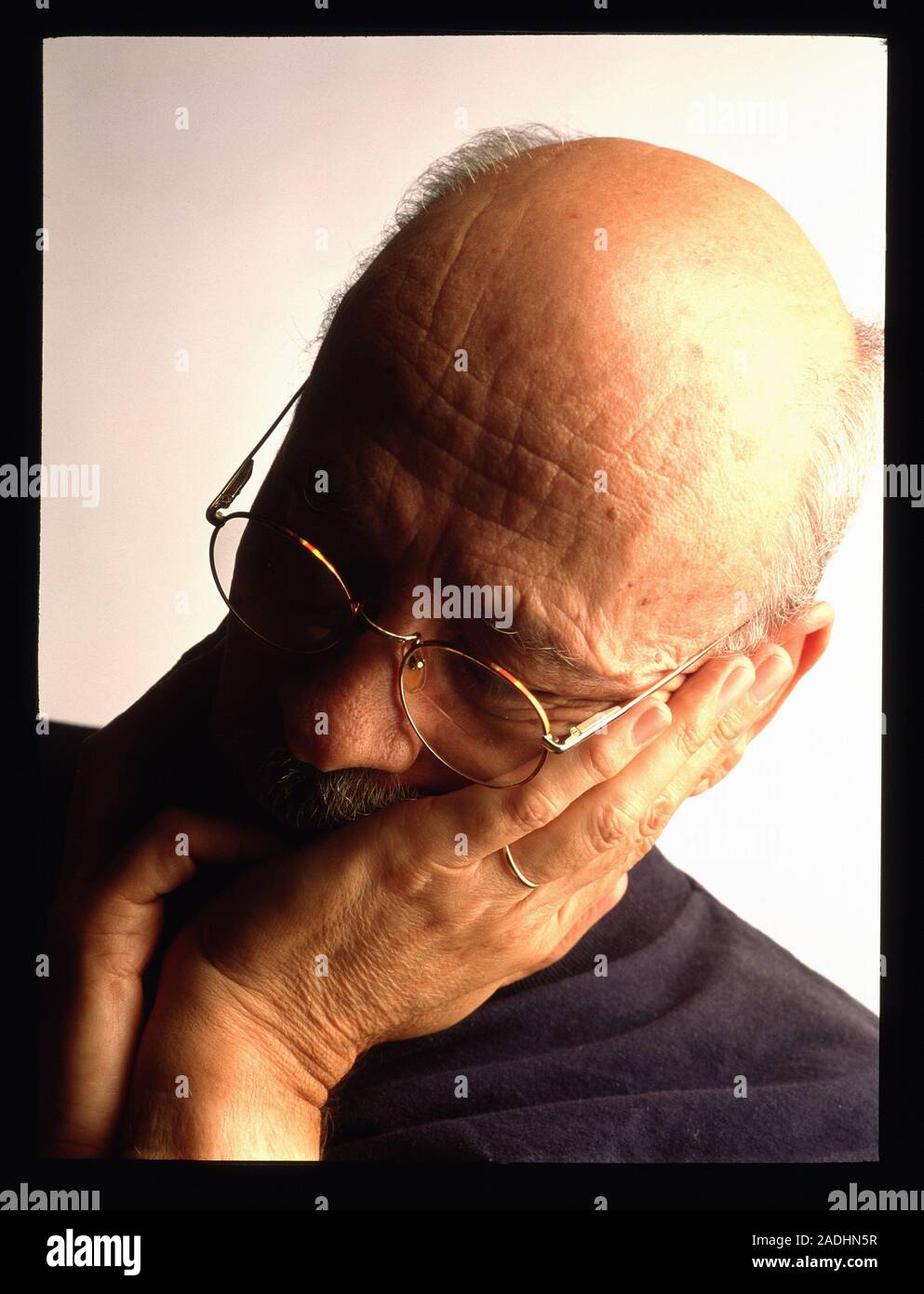 Depression. Portrait of an elderly man holding his hands to his face in ...