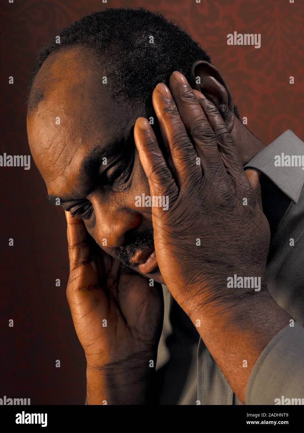 MODEL RELEASED. Depressed man cupping his face in his hands Stock Photo