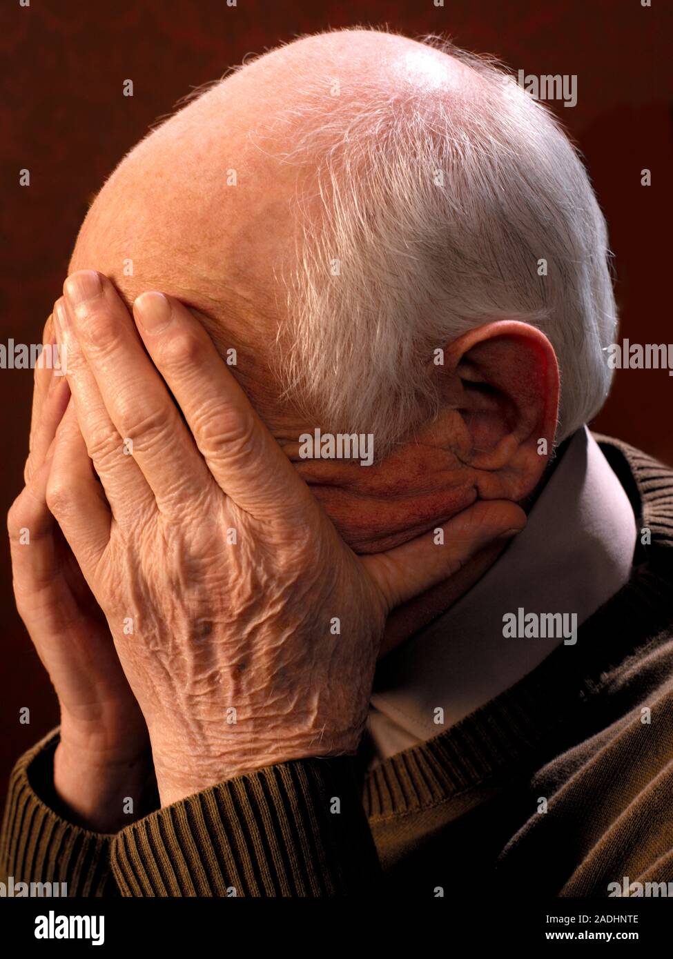 MODEL RELEASED. Depressed man cupping his face in his hands Stock Photo