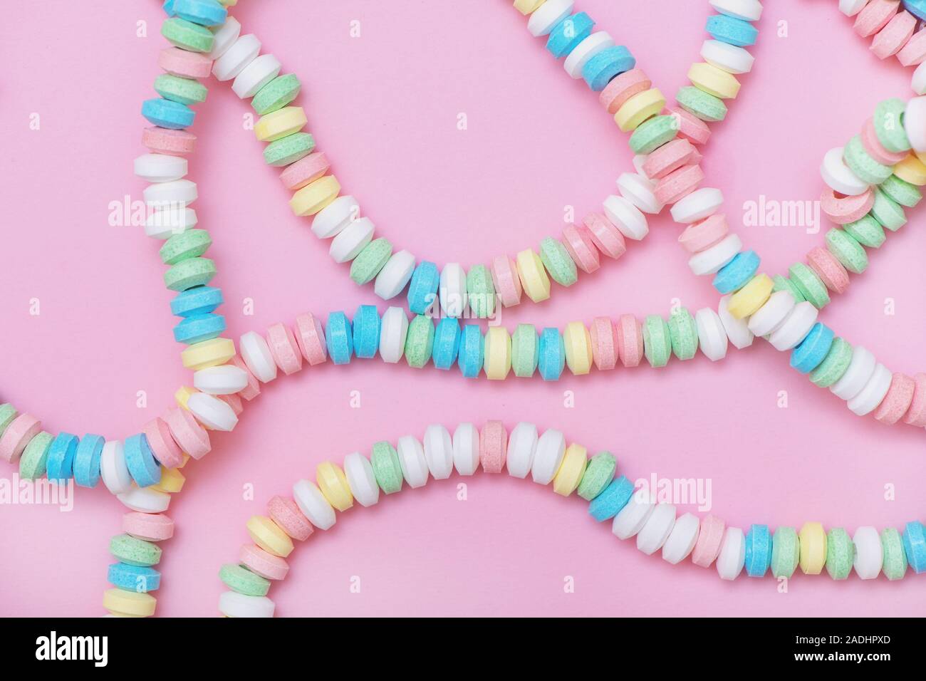 Candy necklace on pink pastel colored background. Top view. Stock Photo