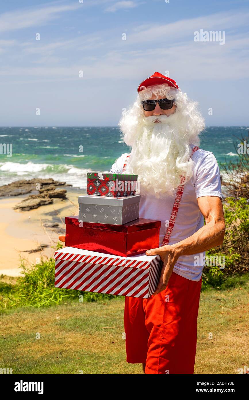 Santa Claus holds gift the ocean on backgraund. Australia, Christmas in summer time Stock - Alamy