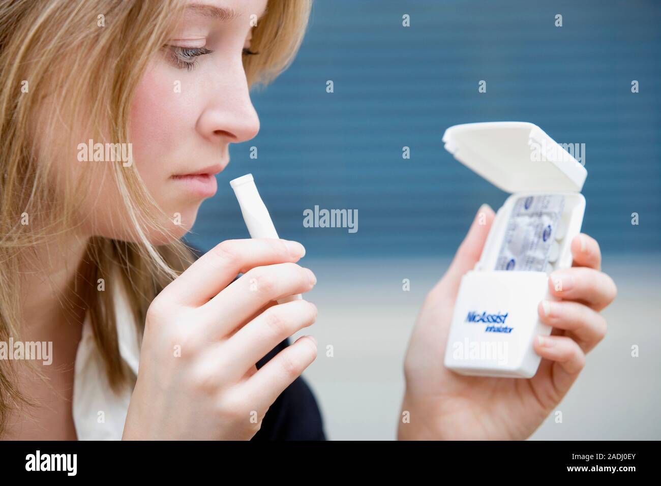 MODEL RELEASED. Nicotine inhalator. Woman using a nicotine inhaler to help her quit smoking. This is the NicAssist inhalator marketed by Boots with ca Stock Photo