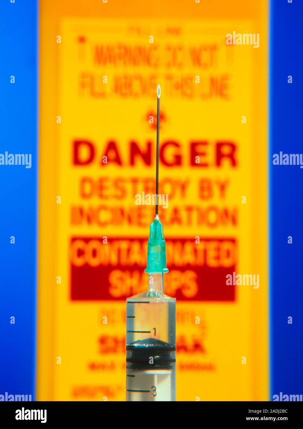 Syringe. Closeup of a hypodermic syringe pointing upwards in front of