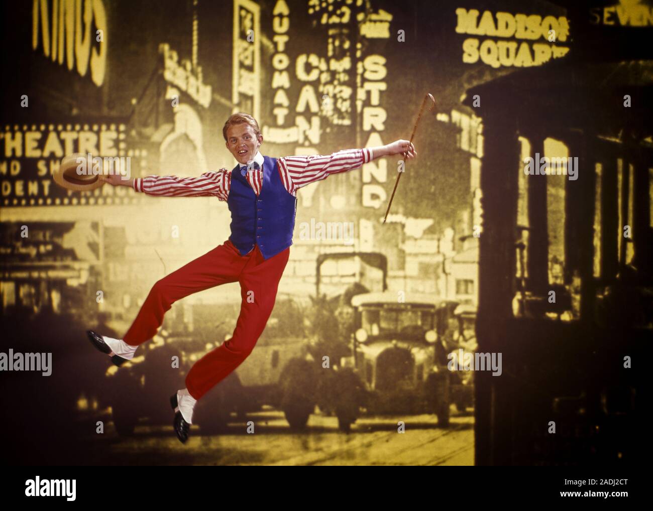 1970s VAUDEVILLE ERA TAP DANCING MAN JUMPING UP AND CLICKING HIS HEELS TOGETHER WITH SEPIA TONED 1920s SCENE OF TIMES SQUARE NYC - kd2846 PHT001 HARS STYLE COMMUNICATION VEHICLE HEELS YOUNG ADULT LEAPING MANHATTAN JOY LIFESTYLE SATISFACTION ACTOR CELEBRATION STUDIO SHOT CANE UNITED STATES COPY SPACE FULL-LENGTH PERSONS INSPIRATION UNITED STATES OF AMERICA AUTOMOBILE MALES ENTERTAINMENT CONFIDENCE TRANSPORTATION VEST TAP EYE CONTACT PERFORMING ARTS ACT DREAMS MIDTOWN NEON HAPPINESS HIS LEAP PERFORMER AND AUTOS EXCITEMENT GOTHAM PRIDE UP VAUDEVILLE ENTERTAINER NYC OCCUPATIONS AUTOMAT CONCEPTUAL Stock Photo