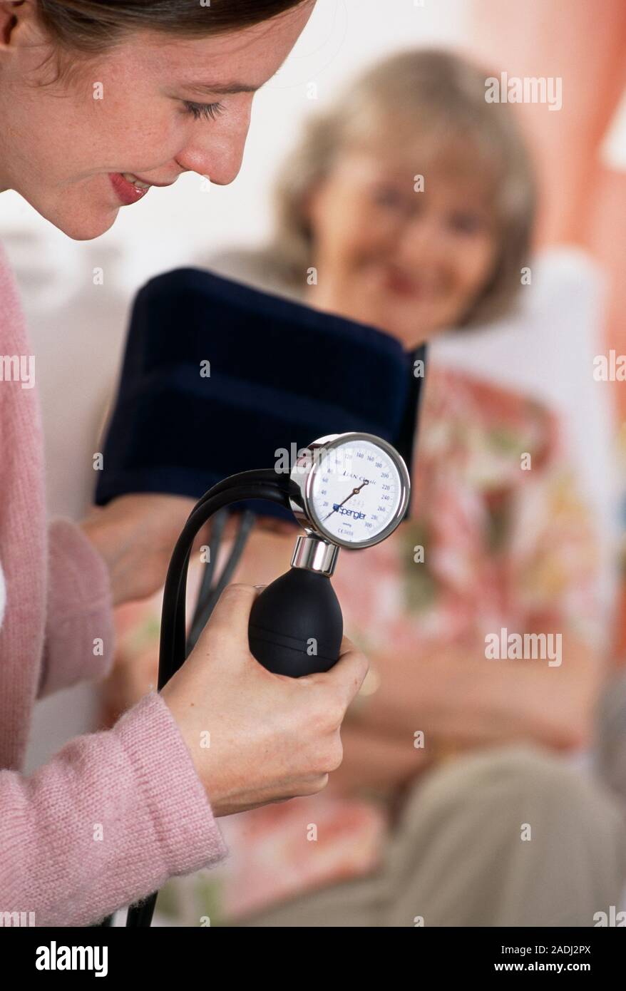 Blood pressure gauge. Woman holding a sphygmomanometer, an instrument used  to measure blood pressure. The cuff (black) is placed on the upper arm of t  Stock Photo - Alamy