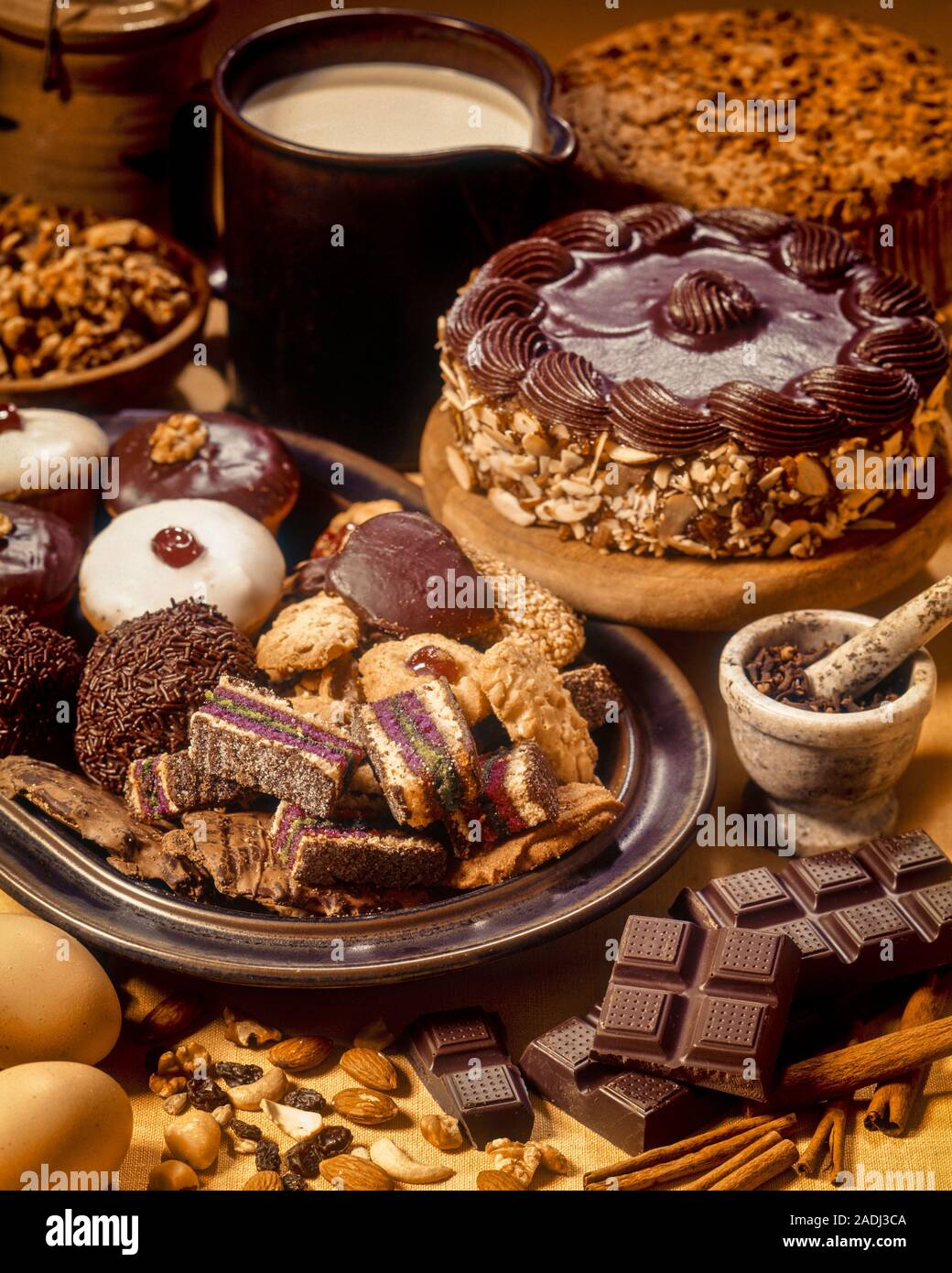 1970s INGREDIENTS FOR VARIETY OF CHOCOLATE PASTRIES CAKES PETITS FOURS COOKIES AMID NUTS RAISINS CREAM BAKING CHOCOLATE EGGS - kf12953 PHT001 HARS PETIT FOUR Stock Photo