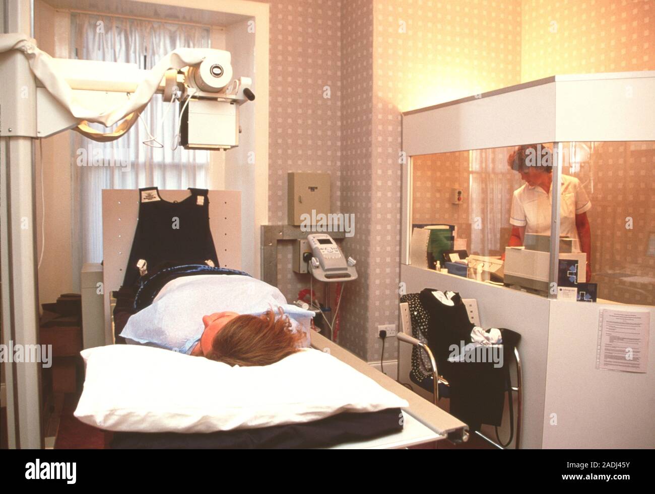 Xray examination. Xrays emitted from an overhead machine (upper left) pass through the patient