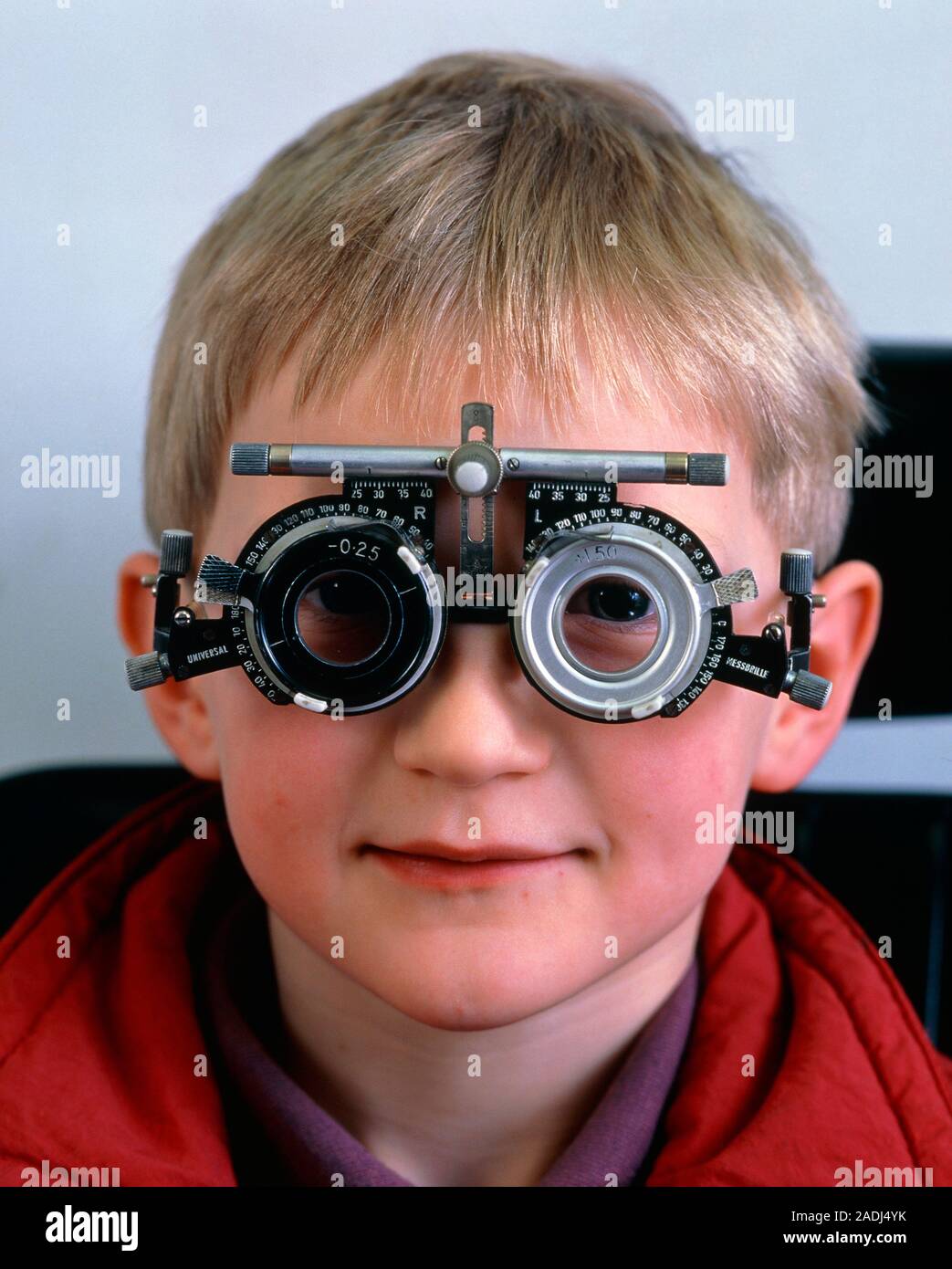 Eye test. Ophthalmology test frames fitted to a young boy for assessing