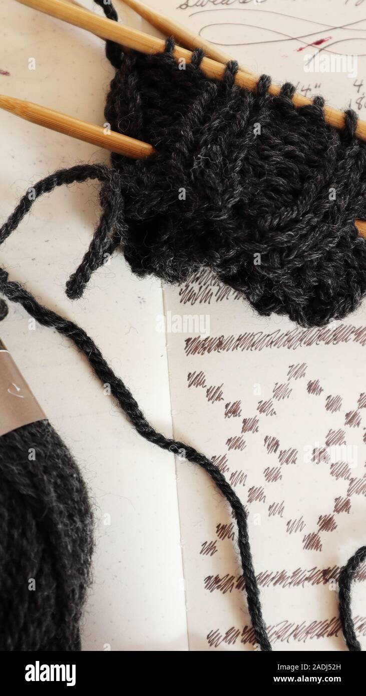 Handknit partially finished sweater and the handwritten pattern ...