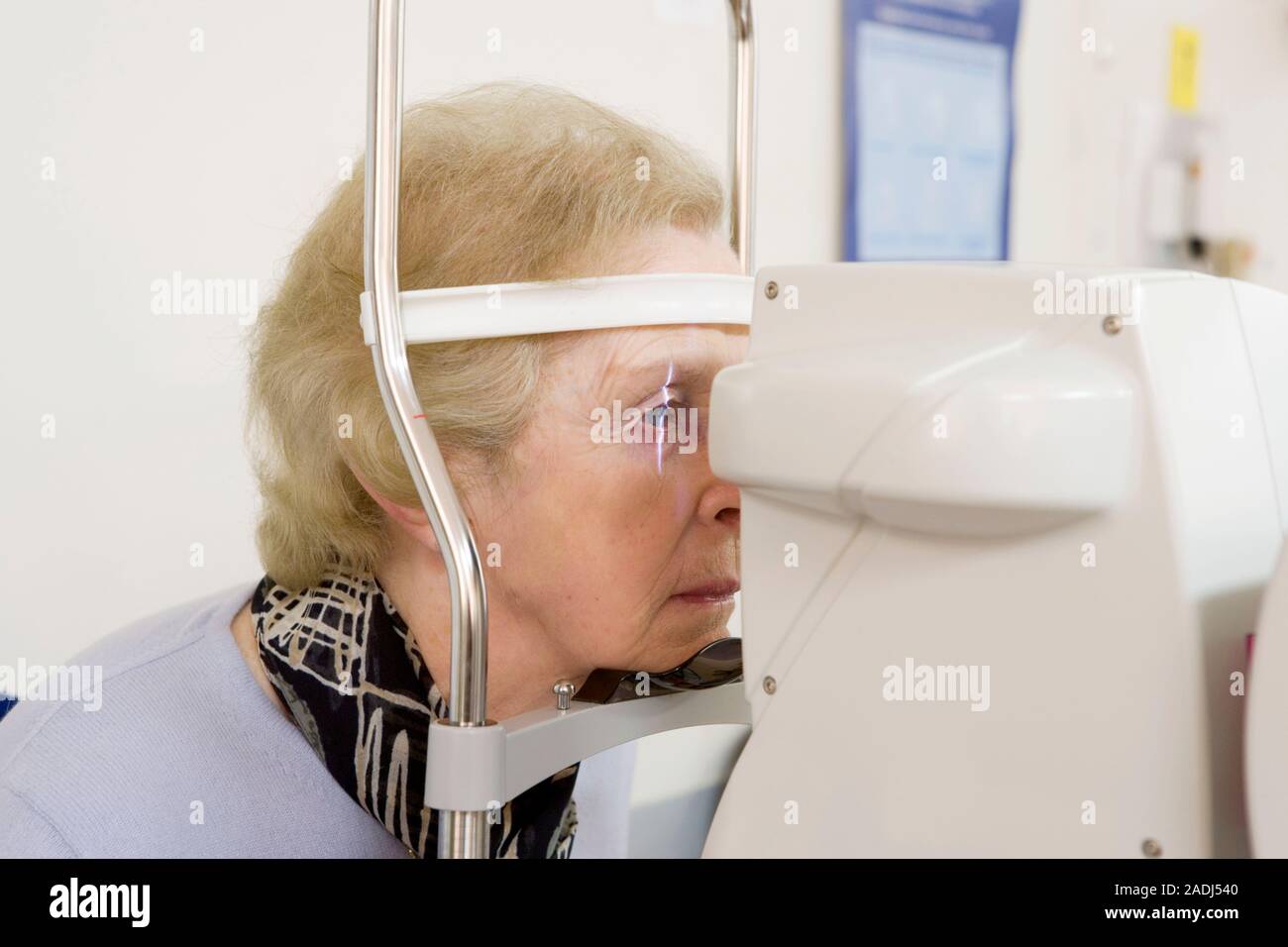 MODEL RELEASED. Eye measurements. Patient having her eyes scanned by an ...