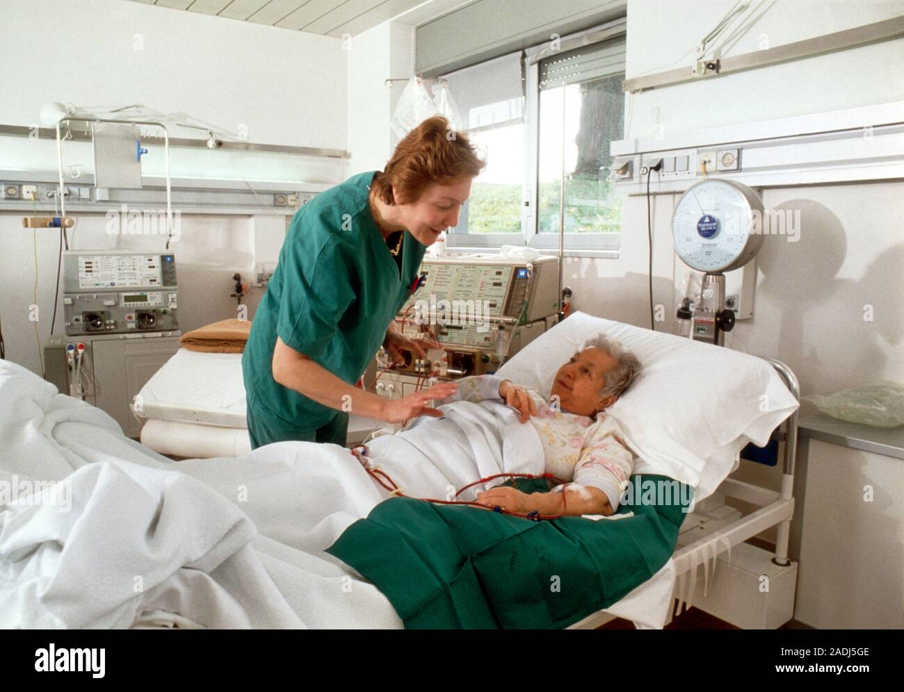 Kidney dialysis. Nurse comforts an elderly woman during the procedure