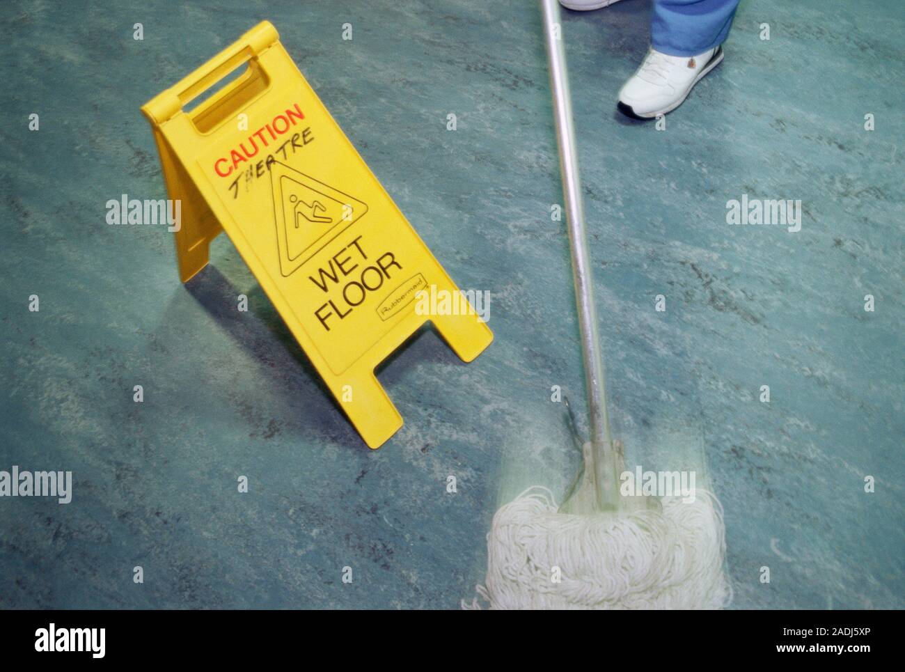 Hospital hygiene. Mop being used by a cleaner to clean a floor in a ...