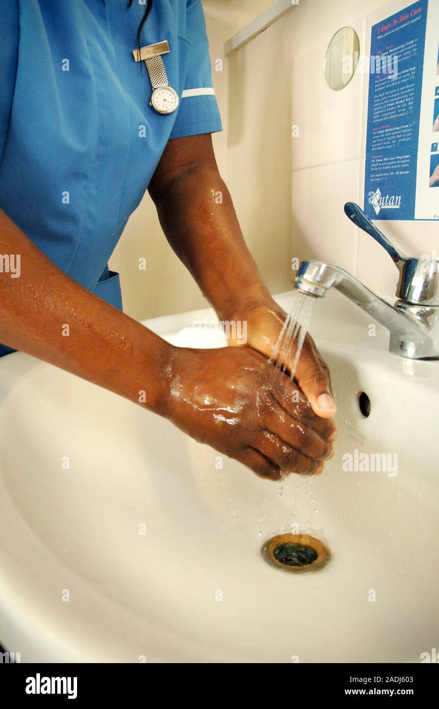 Hospital hygiene. Nurse rinsing her hands at a sink. Cleanliness in