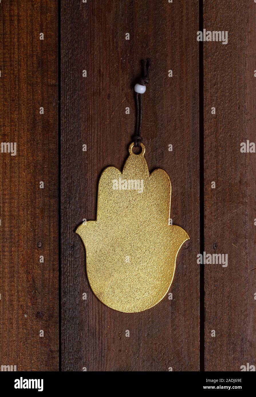 protective amulet Fatima Hamsa's hand without a picture hanging on a rough wooden door Stock Photo