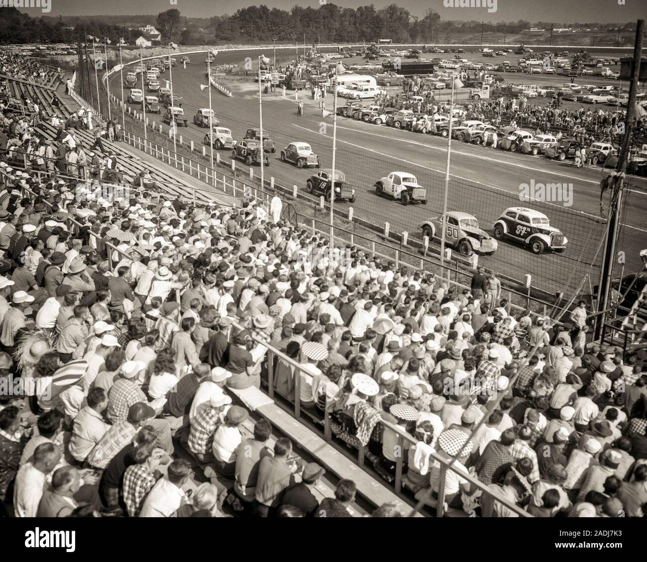 1950s CROWD IN STANDS AT 20 MILE STOCK CAR RACE ON ONE-MILE DIRT TRACK AT LANGHORNE MOTOR SPEEDWAY 1926-1971 PENNSYLVANIA USA - m655 HAR001 HARS TEENAGE GIRL TEENAGE BOY ENTERTAINMENT TRANSPORTATION B&W NORTH AMERICA GOALS NORTH AMERICAN WIDE ANGLE TEMPTATION LEISURE STRENGTH STRATEGY COURAGE AUTOS EXCITEMENT EXTERIOR PA POWERFUL RECREATION PRIDE A AT IN ON THE OCCUPATIONS PROFESSIONAL SPORTS MOTION BLUR CONCEPTUAL AUTOMOBILES STYLISH VEHICLES BUCKS COUNTY STANDS FANS LANGHORNE PRECISION TOGETHERNESS BLACK AND WHITE HAR001 OLD FASHIONED Stock Photo