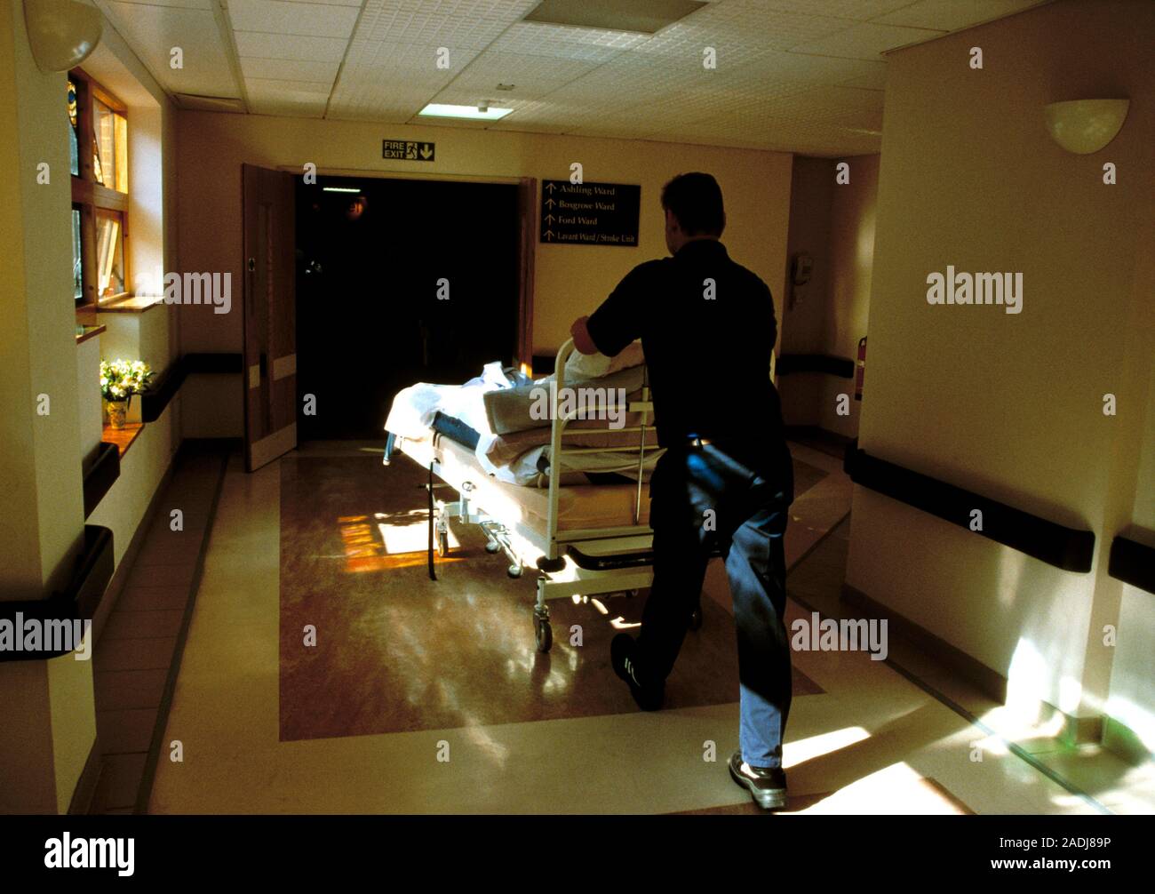 Patient transport. Hospital porter moving a bed bound patient around a