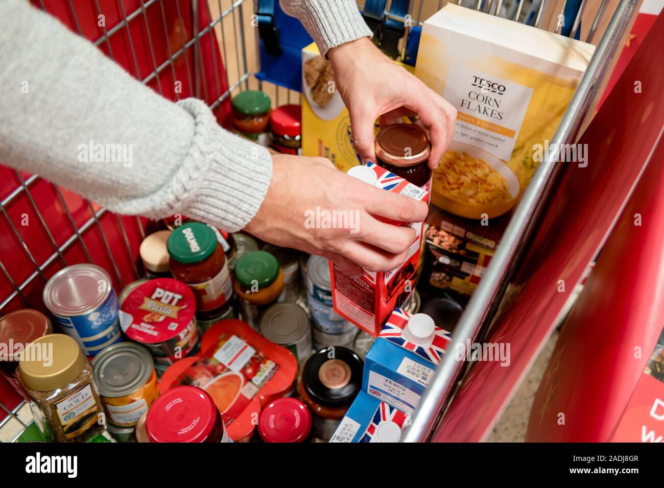 A volunteer sorts donations in a trolley at the supermarket national food bank collection Stock Photo