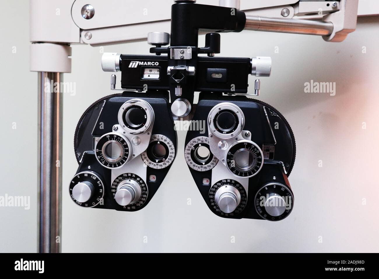 Phoropter (eye testing machine) on a movable arm and a white wall in