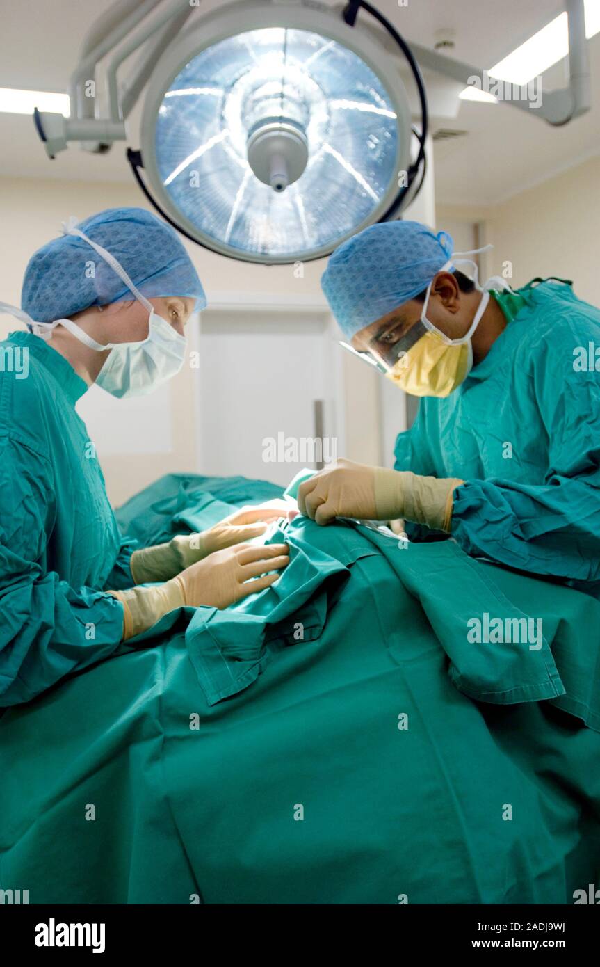 MODEL RELEASED. Surgeons operating. Surgical team carrying out an ...