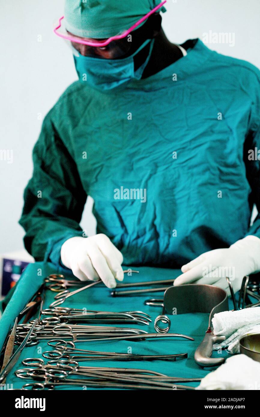 MODEL RELEASED. Preparing instruments for surgery. Theatre assistant