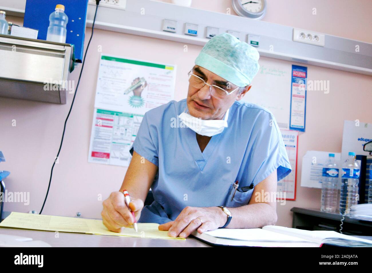 MODEL RELEASED. Anaesthetist writing in a patient's record after an ...