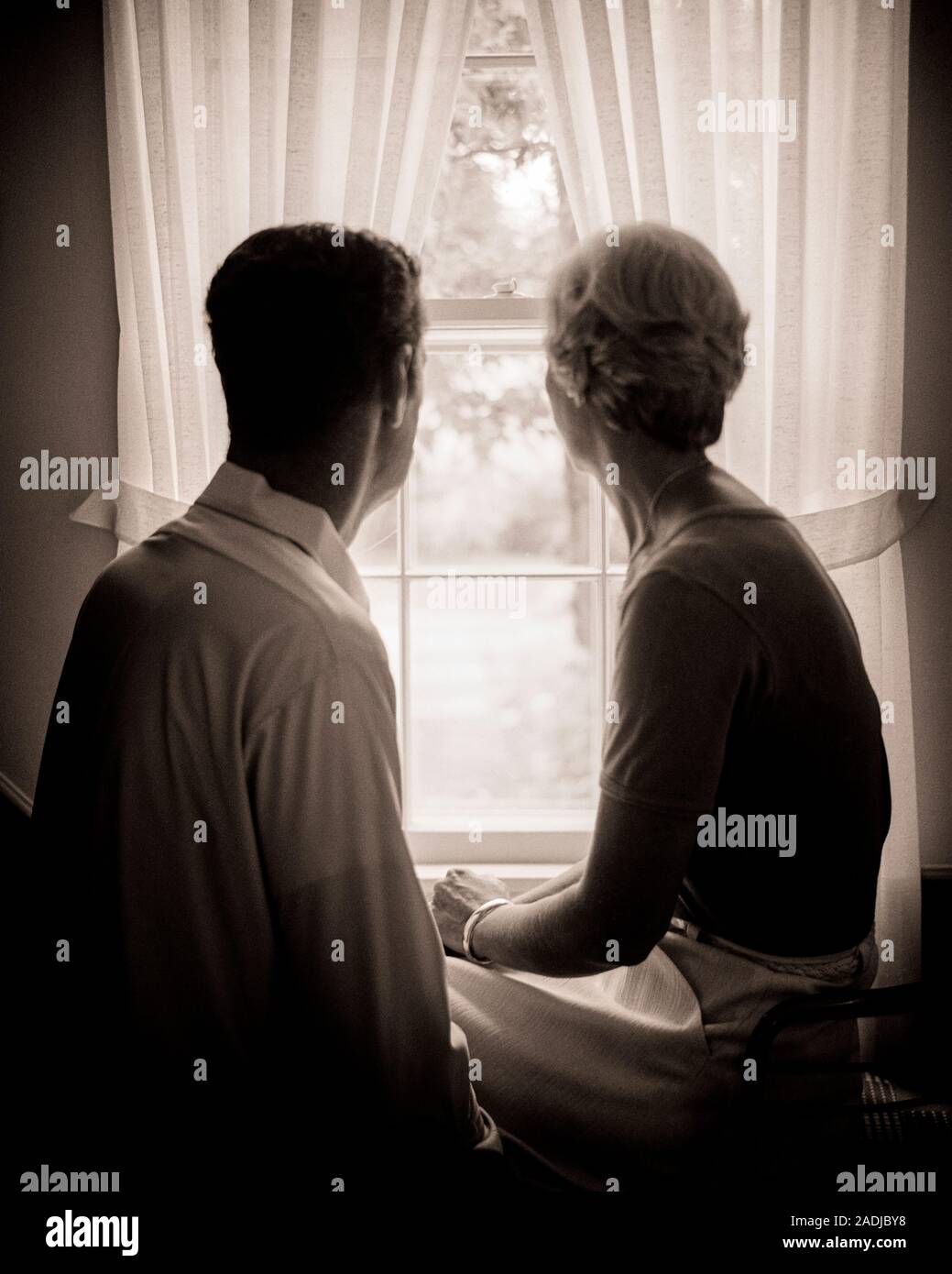 1970s ANONYMOUS SILHOUETTE OF MATURE MAN AND WOMAN LOOKING OUT OF WINDOW WITH TIE BACK CURTAINS - s20513 HAR001 HARS NOSTALGIA OLD FASHION GRAPHIC RETIRED FEAR TEAMWORK WORRY MYSTERY STRONG PROBLEM LIFESTYLE ELDER FEMALES MARRIED MOODY SPOUSE HUSBANDS ILLNESS HOME LIFE COPY SPACE FRIENDSHIP HALF-LENGTH LADIES PERSONS INSPIRATION CARING MALES RISK AILMENT RETIREMENT SERENITY SILHOUETTES SPIRITUALITY SENIOR MAN SENIOR ADULT TROUBLED B&W CONCERNED OUTLINE PARTNER SADNESS SENIOR WOMAN RETIREE SUFFERING OLD AGE OLDSTERS CRISIS OLDSTER SILHOUETTED AND FEELING MOOD POSSIBILITIES ELDERS CONCEPTUAL Stock Photo