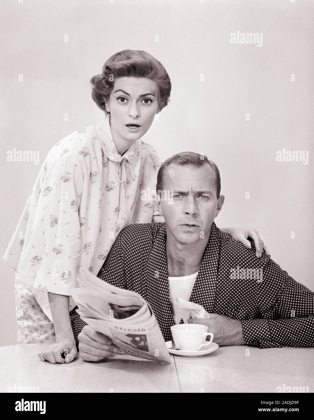 1950s PORTRAIT OF COUPLE IN BATHROBES LOOKING AT CAMERA WITH QUESTIONING EXPRESSION  - s5905 CRR001 HARS ALARM NOSTALGIC PAIR NEWS SUBURBAN URBAN AGE OLD TIME SURPRISE NOSTALGIA OLD FASHION COMMUNICATION SHOCK YOUNG ADULT INFORMATION WORRY FEMALES MARRIED STUDIO SHOT ROBE SPOUSE HUSBANDS HOME LIFE COPY SPACE FRIENDSHIP HALF-LENGTH LADIES FROWN PERSONS MALES PAJAMAS AMERICANA TROUBLED B&W CONCERNED FROWNING MORNING PARTNER EYE CONTACT BRUNETTE DOT BEVERAGE MATE AND QUESTION TABLETOP MAN AND WOMAN PEOPLE MEN OF NIGHTGOWN CONNECTION CONCEPTUAL BRUNCH MANLY STYLISH MIDDLE AGE MID-ADULT Stock Photo