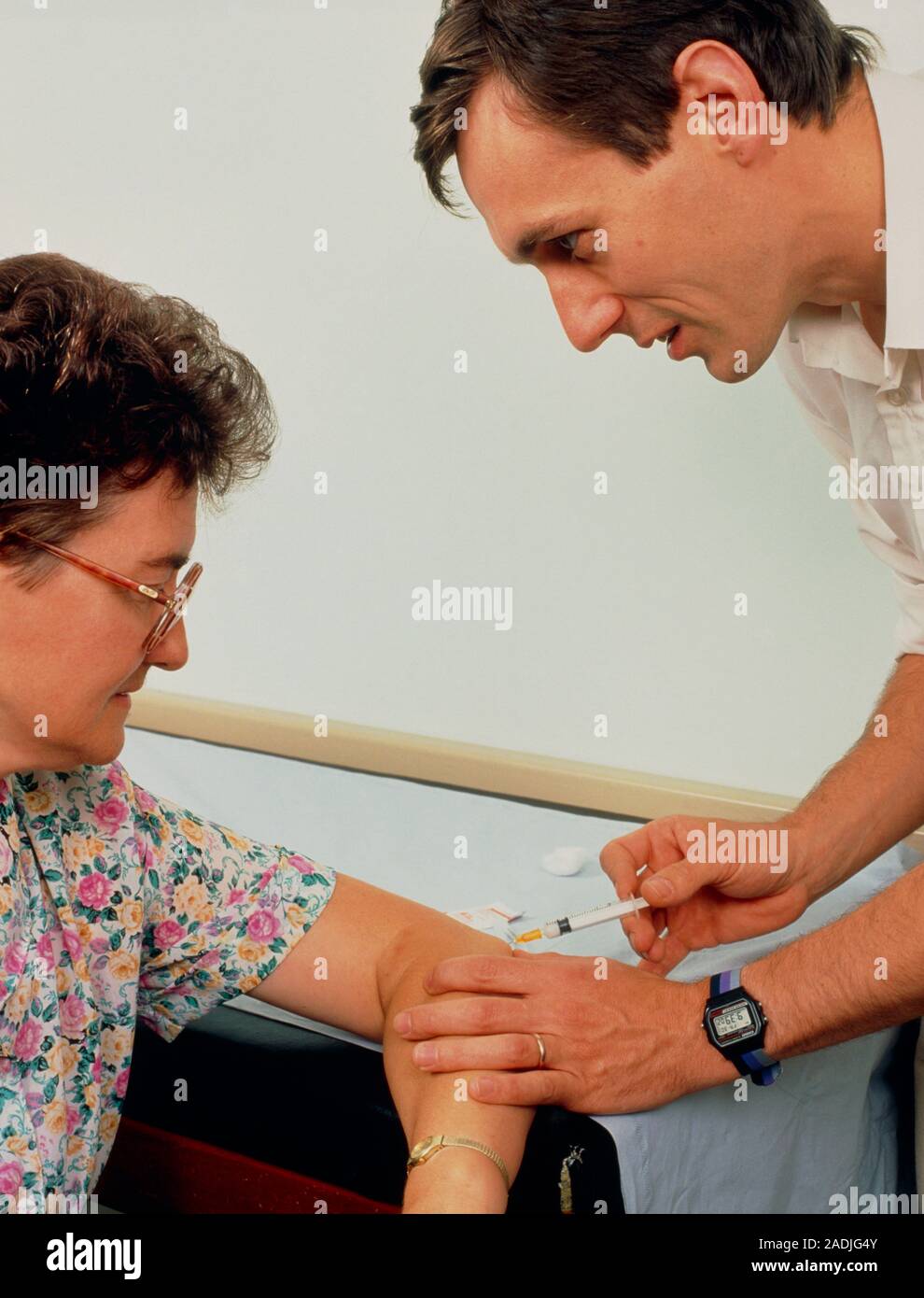 General practice doctor giving a corticosteroid injection to a patient suffering from tennis
