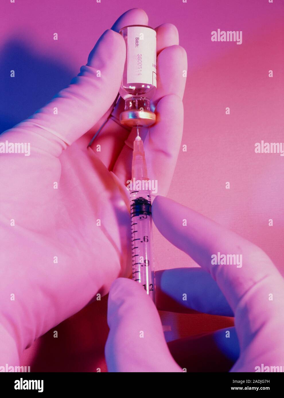 Hypodermic syringe. Hypodermic syringe being filled from a vial. A