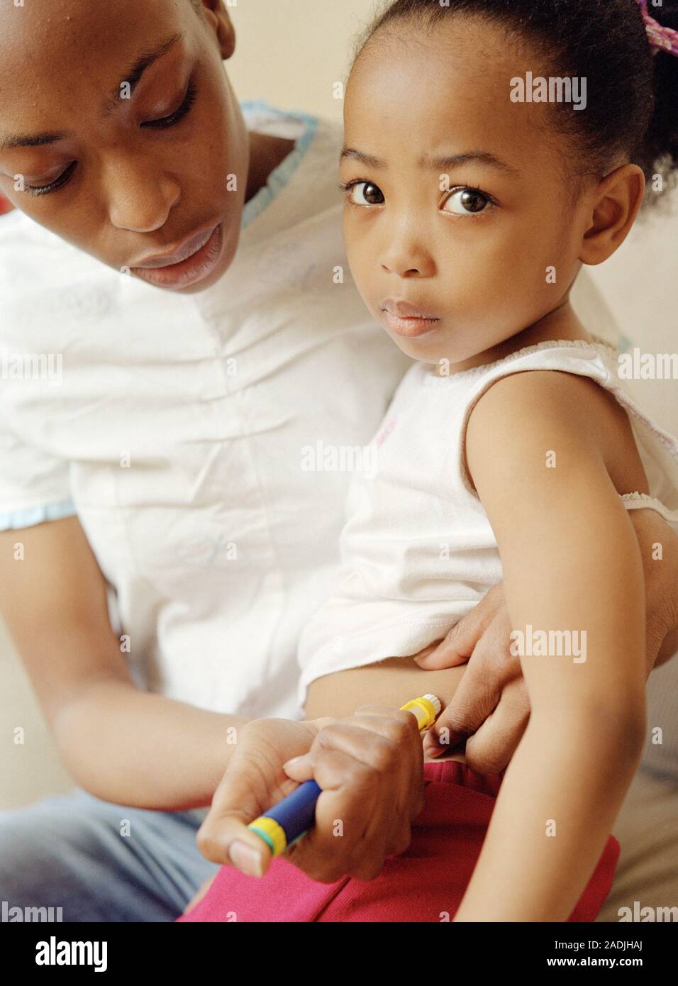 Insulin injection. Mother administering her fouryearold diabetic