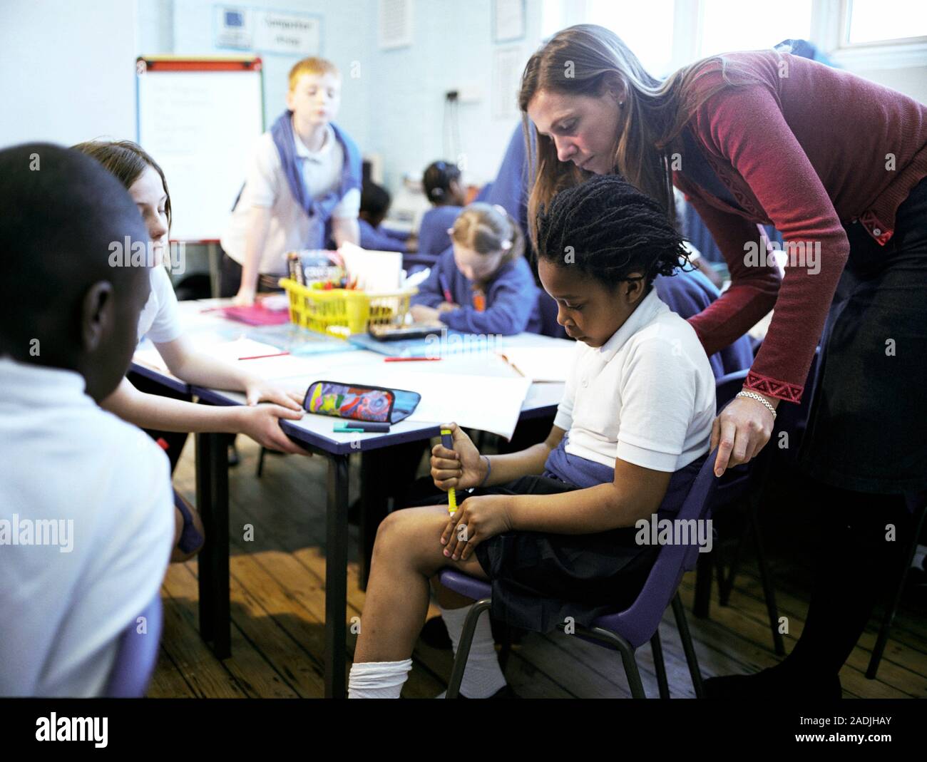 Insulin injection. Teacher watching a diabetic schoolgirl inject