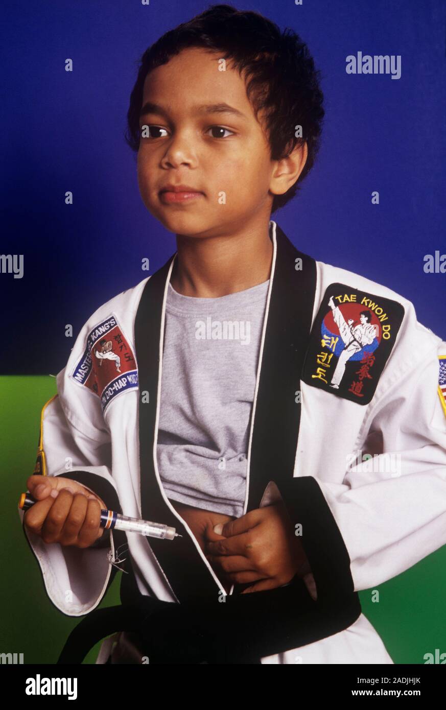 Insulin injection. Diabetic boy wearing a tae kwan do (a type of