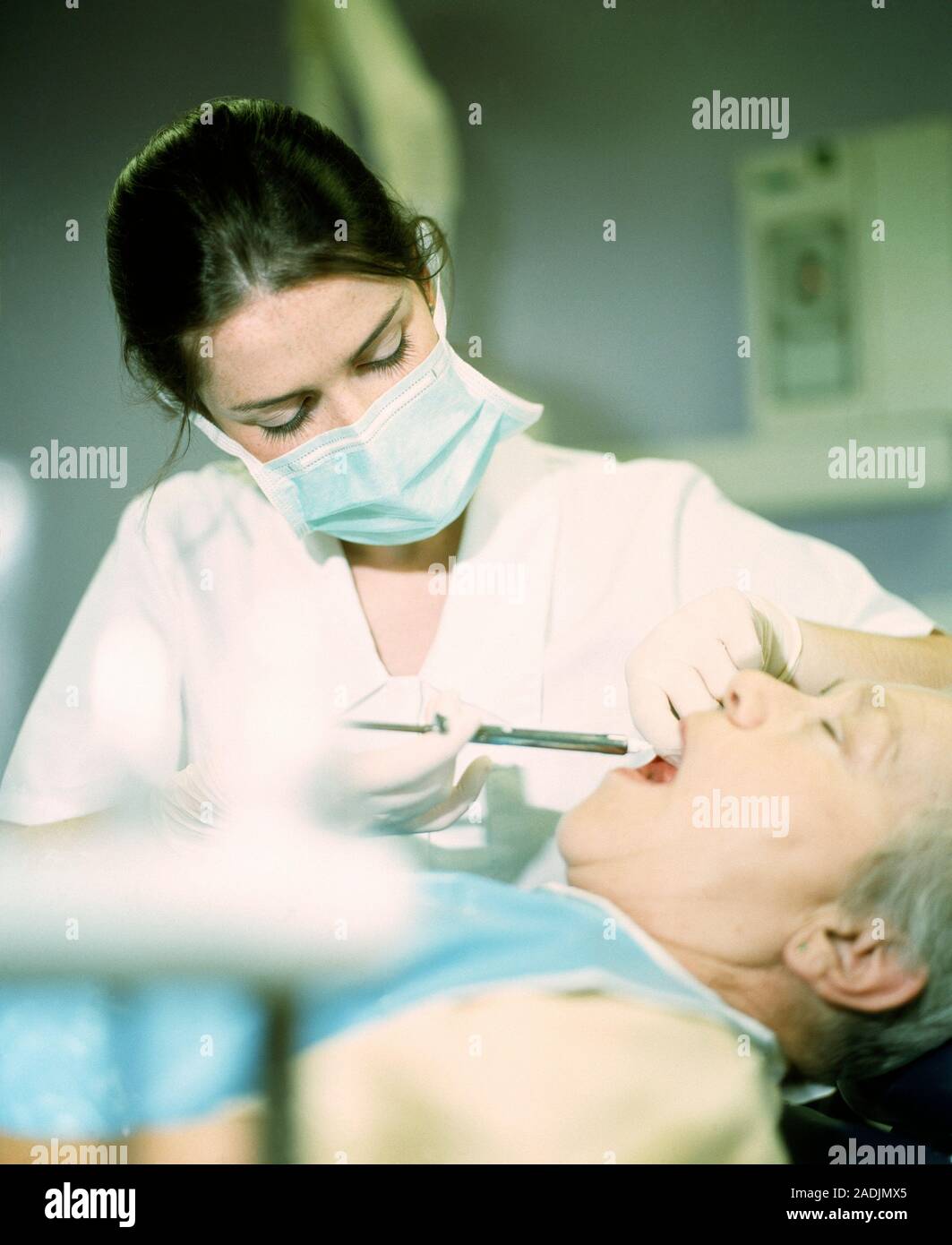 Dental anaesthetic. Dental worker injecting a local anaesthetic into