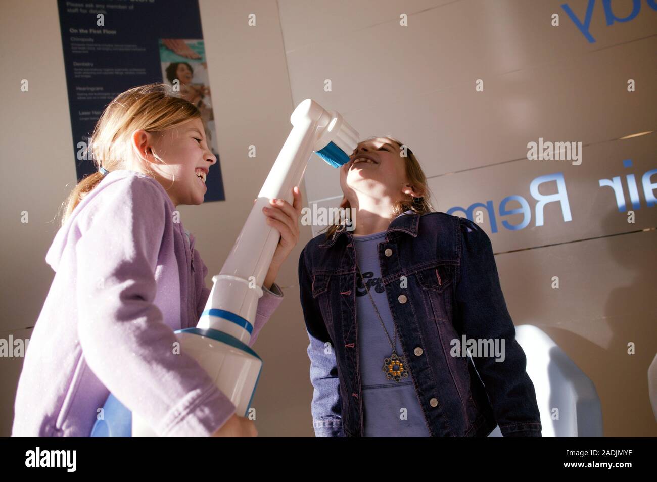 Toothbrush Playing Giant electric toothbrush. Two children playing with a giant electric ...