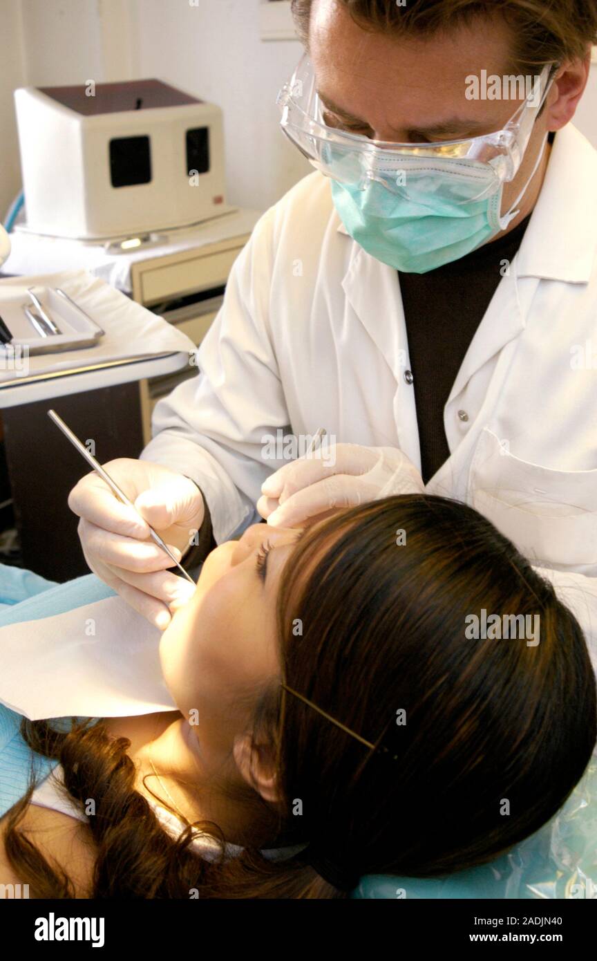 MODEL RELEASED. Plaque removal. Dentist scraping a female patient's teeth Stock Photo Alamy