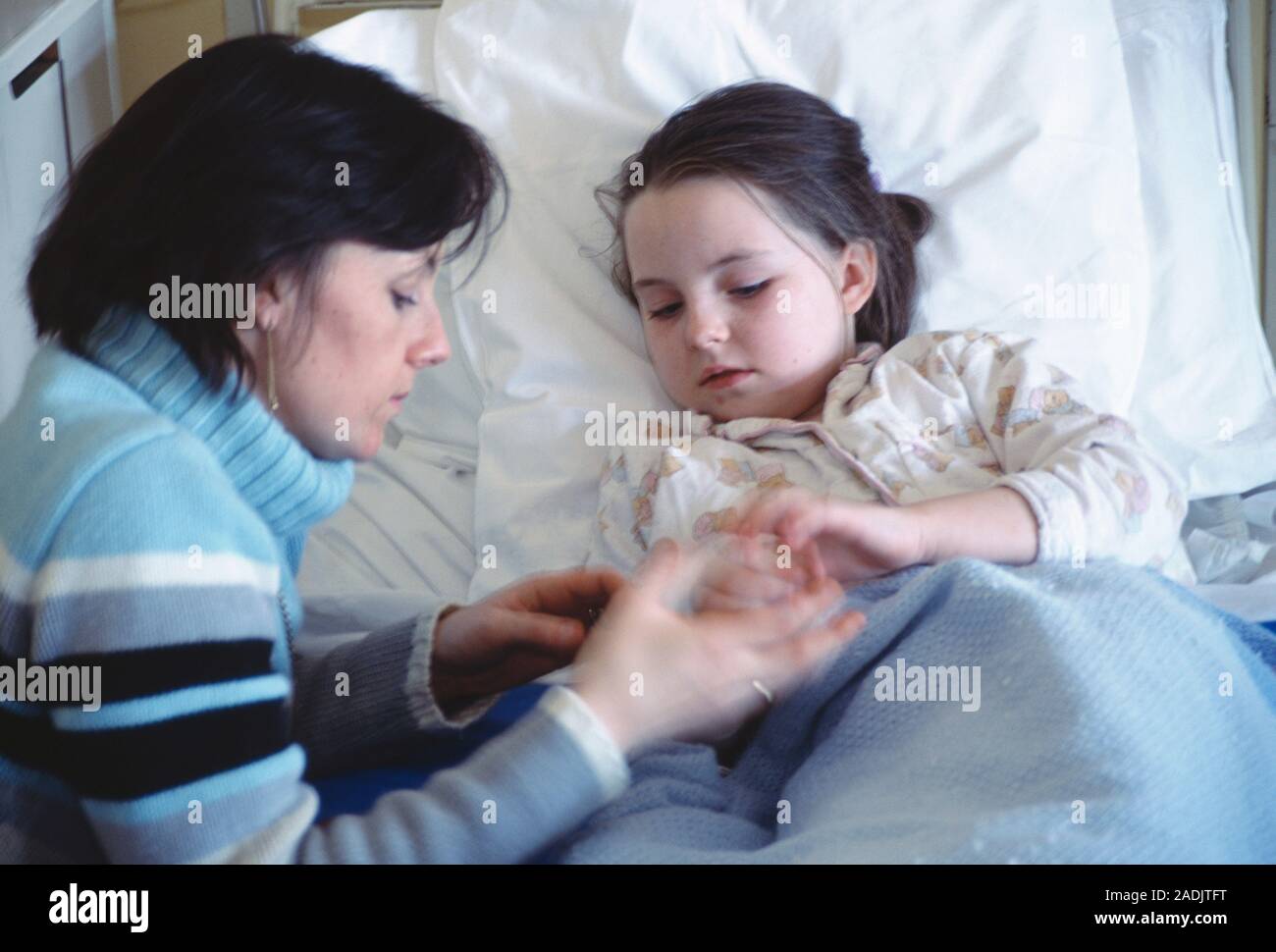 Mother with her ill daughter who is lying in a hospital bed Stock Photo ...