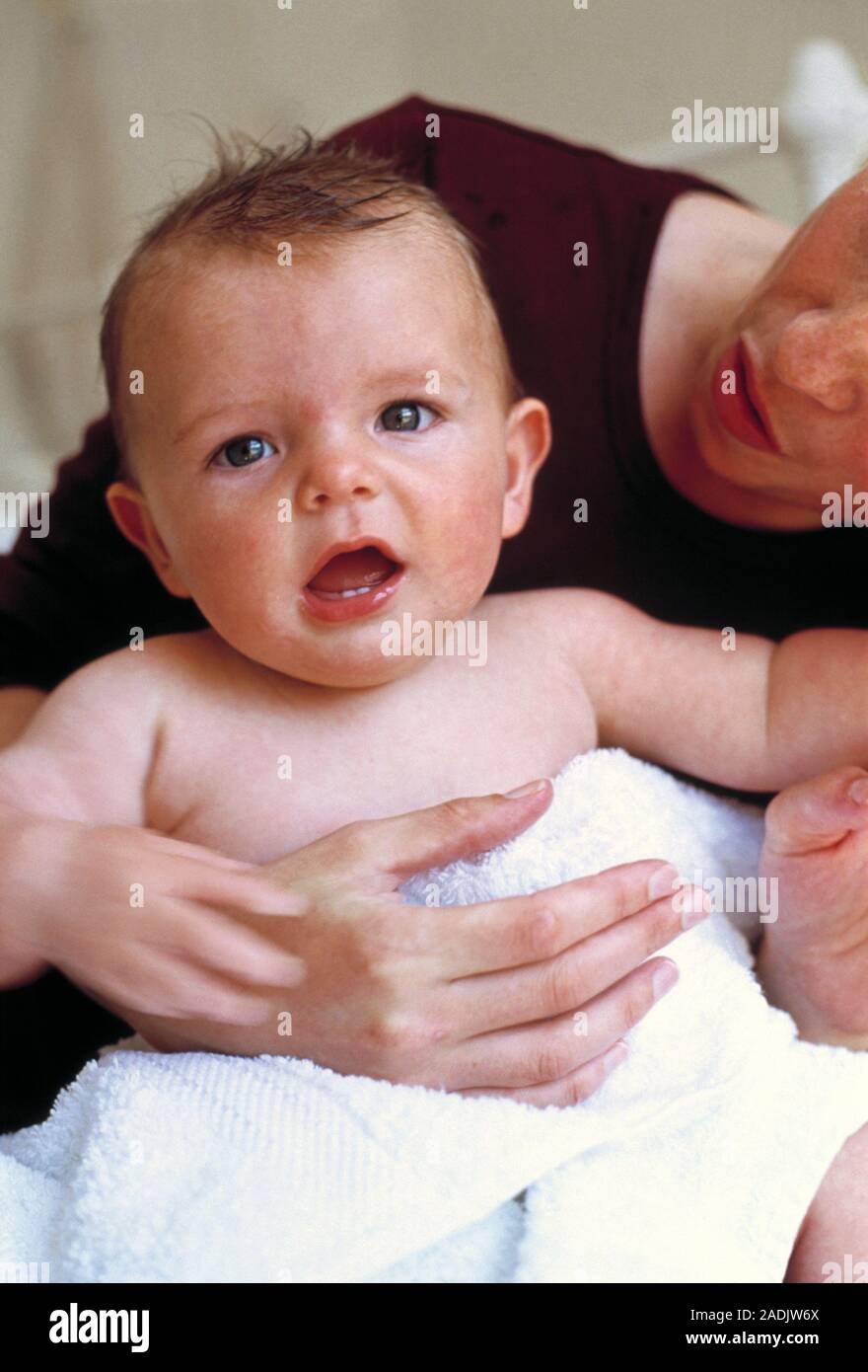 Baby after bath. Mother drying off her sixmonthold baby boy after a