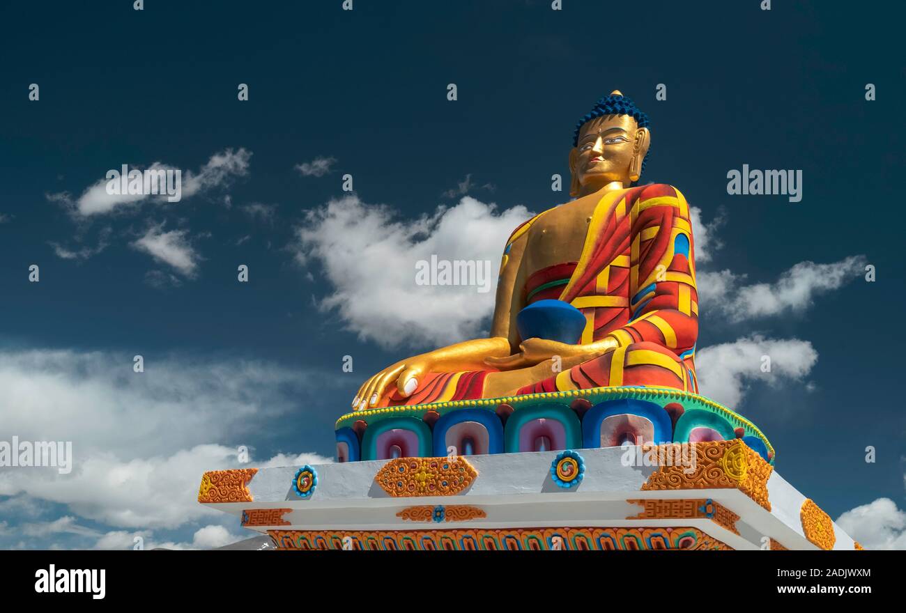Colourful large statue of Buddha against a brilliant blue sky and white clouds in summer on September 17, 2019 in Langza, Himachal Pradesh, India. Stock Photo