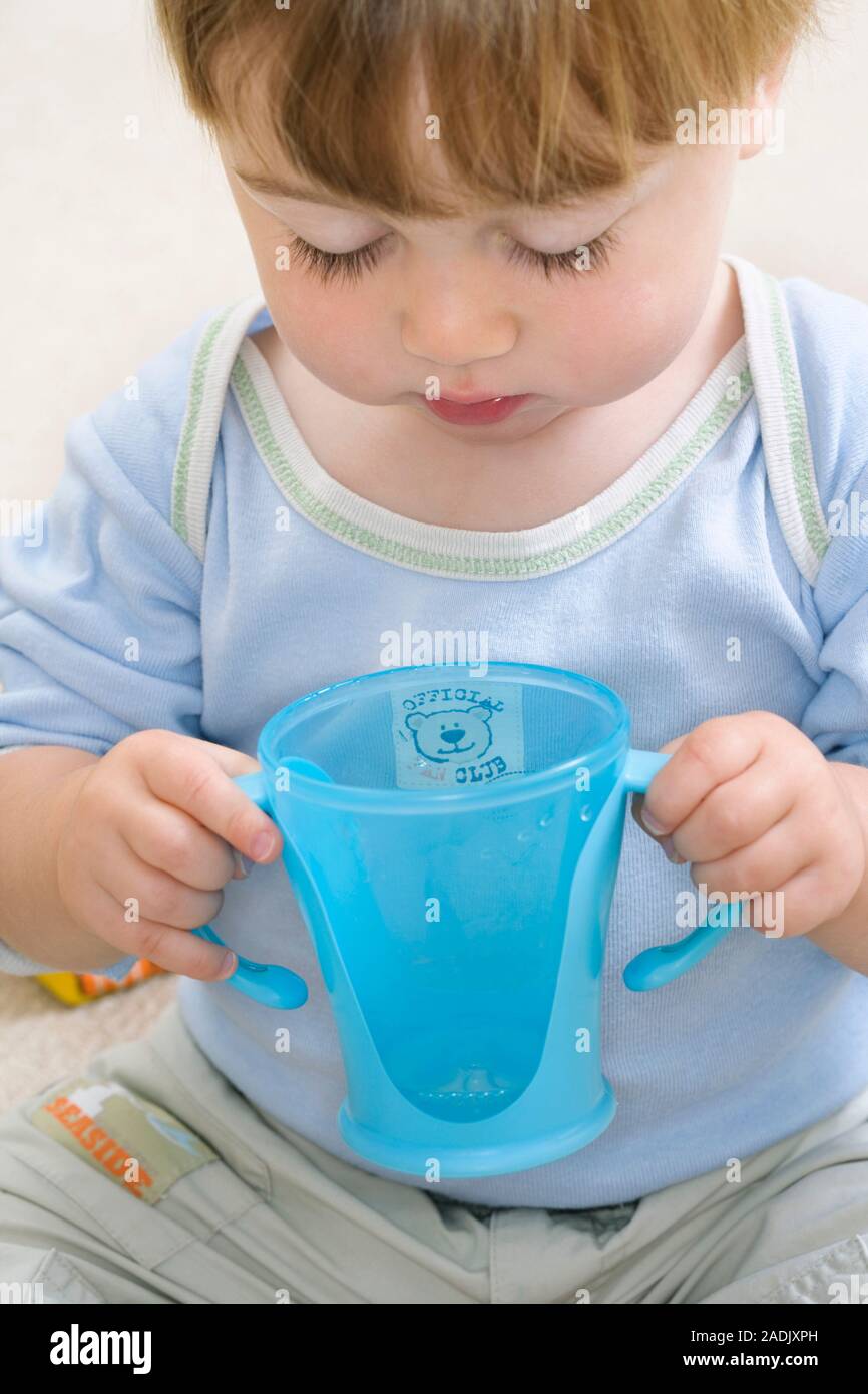 MODEL RELEASED. Toddler drinking from a beaker Stock Photo Alamy