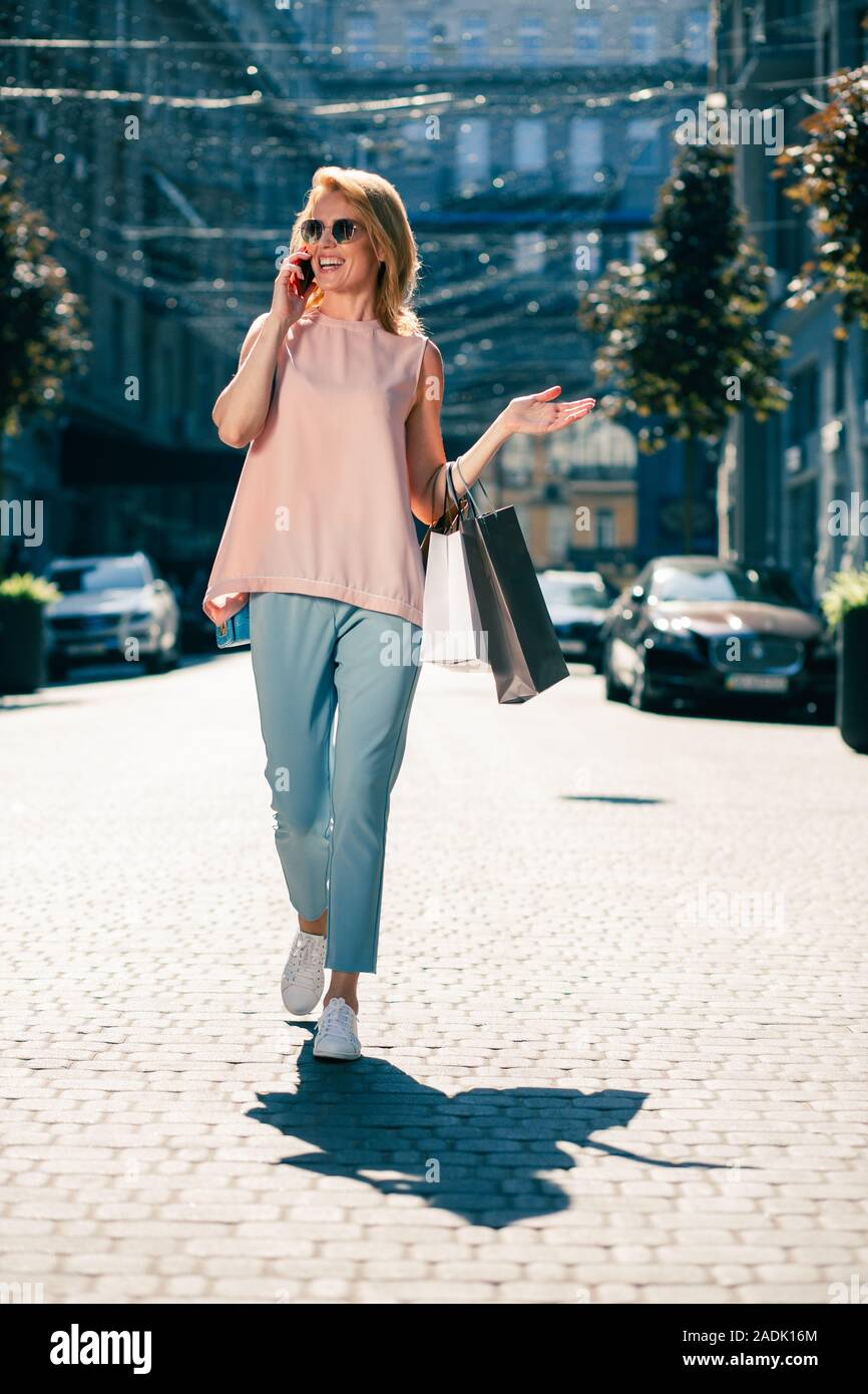Happy woman gesturing while talking on the phone Stock Photo