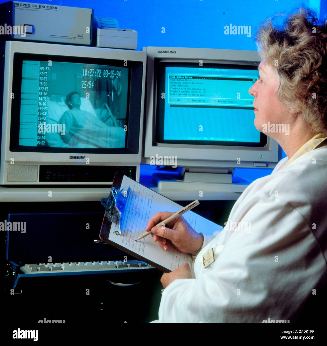 Sleep disorder research. Female researcher uses a television screen to ...