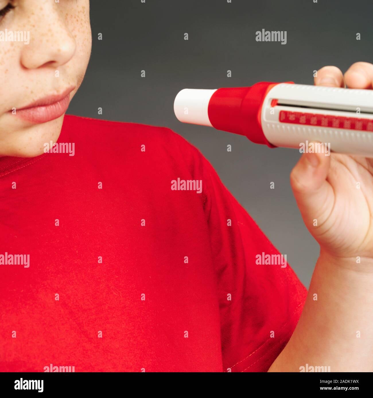 Lung function test. Boy preparing to breathe into a peak flow meter