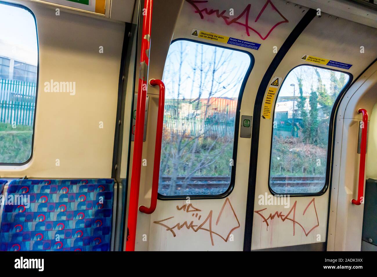 Graffiti inside a London Underground tube train carriage. Subway railway train with graffiti tag, tags. Handstyle tagging on doors of carriage Stock Photo