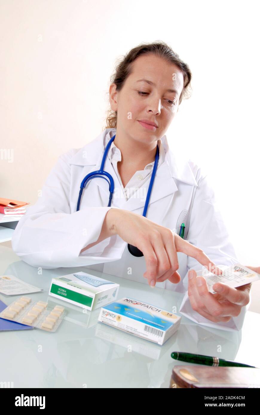 MODEL RELEASED. Smoking cessation. Doctor explaining how to use a