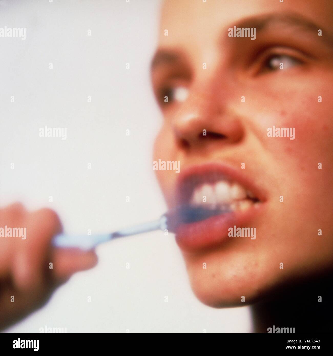 Toothbrushing. Woman brushing her teeth with toothpaste to prevent