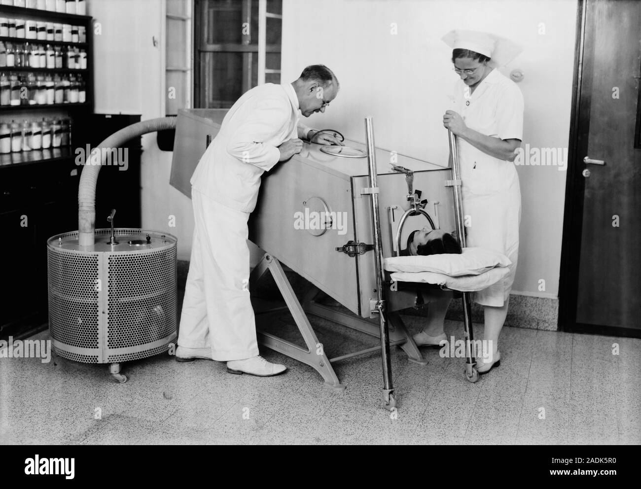 Iron lung, 1940. A man inside an iron lung or ventilator. The iron lung