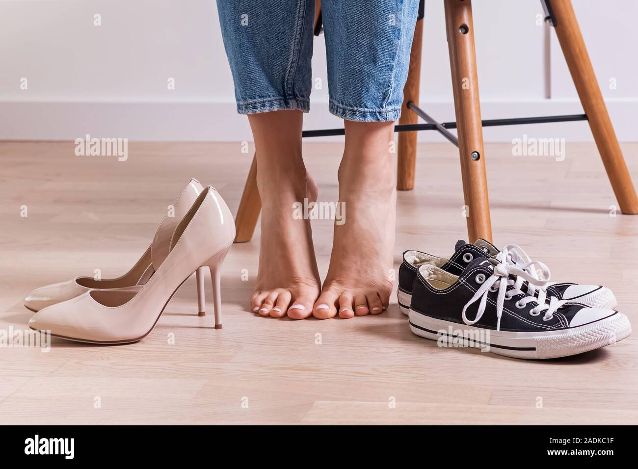 Woman's barefoot and two pairs of shoes. Stock Photo